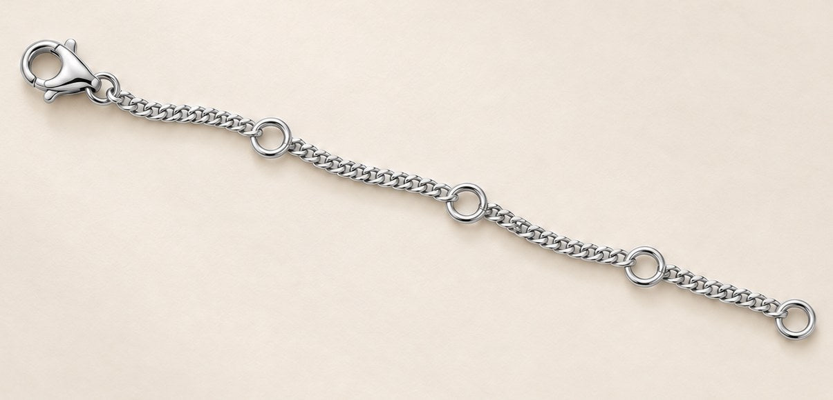 The 4-inch extension chain in 18ct white gold, laid flat, lobster clasp at one end and four adjustment loops along its length